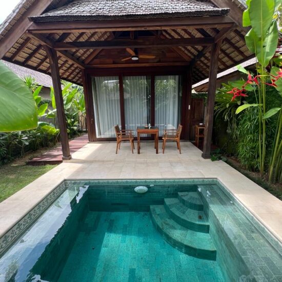 a view from the garden over the pool into a private handcrafted recycled teak villa